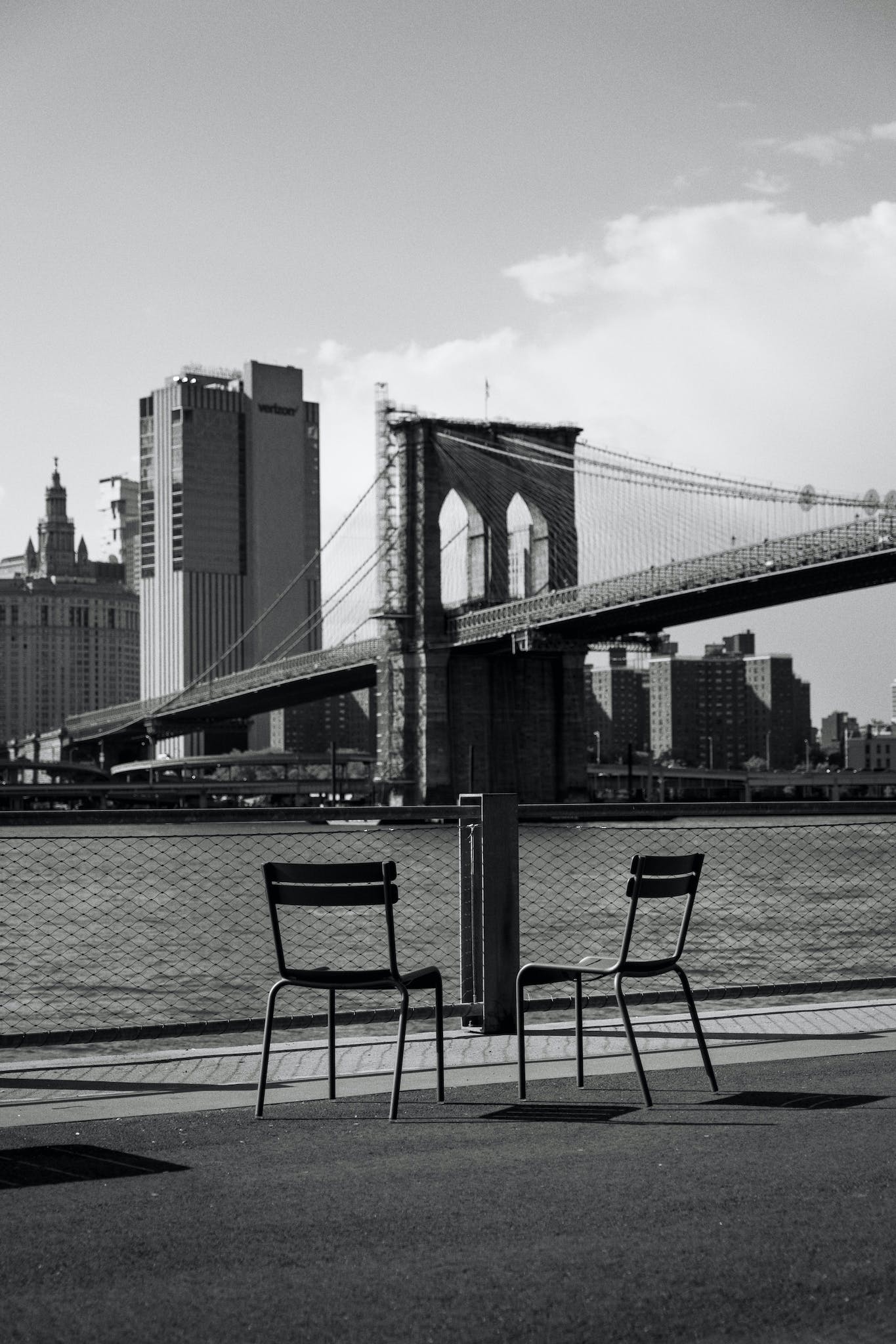 Two Chairs on Waterfront against Brooklyn Bridge